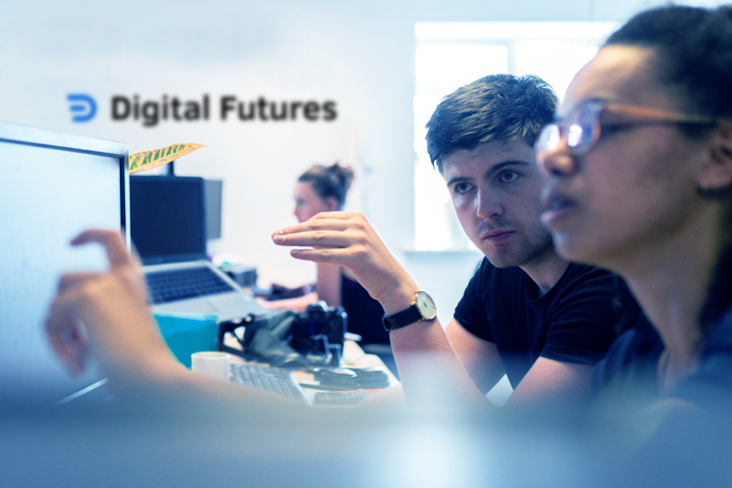 Photo of two colleagues working together on a computer in the Digital Futures office