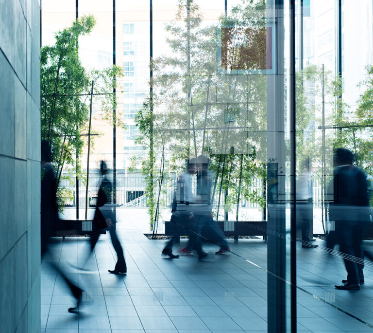 Photo of people walking into an office building entrance lobby