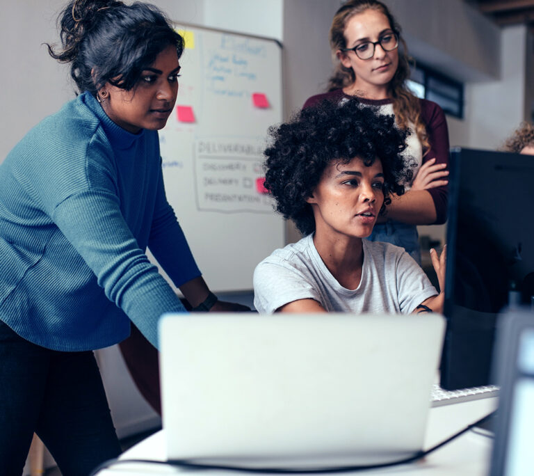 Diverse women working together on computers