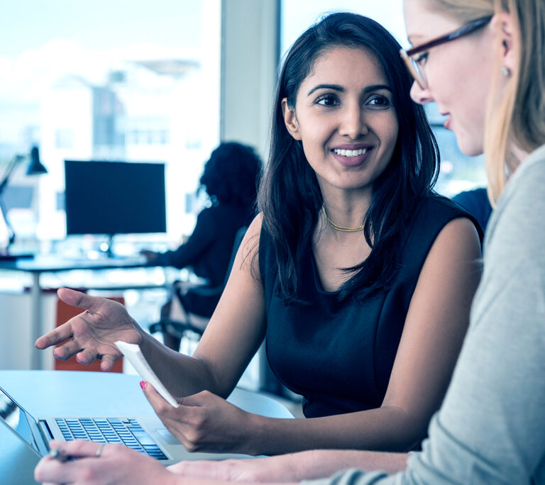 Two women working on laptops